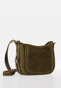 Olivgrüne Wildleder-Crossbody-Tasche mit strukturiertem Design, ausgestattet mit einem gefütterten Schulterriemen und sichtbaren Nähdetails. Dezentes Branding auf der Vorderseite.