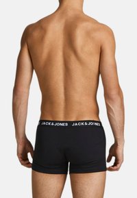 Boxer in cotone nero con una ampia cintura elastica che presenta il marchio bianco "JACK & JONES", mostrando una vestibilità aderente sul retro.