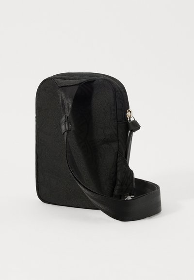 Schwarze Stoff-Crossbody-Tasche mit strukturiertem Muster, rechteckiger Form, verstellbarem Gurt und silbernen Hardware-Details am Reißverschluss.