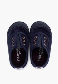 Zapatos de tela azul marino con textura suave, presentan paneles laterales elásticos y ojales en tono dorado. El interior cuenta con un forro acolchado oscuro.