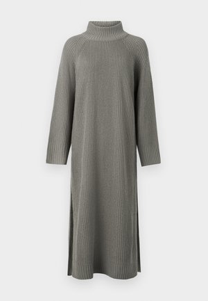 Robe en tricot grise avec un col haut, des manches longues, des poignets côtelés et des fentes latérales pour un meilleur confort de mouvement. Le tissu texturé ajoute de la profondeur.