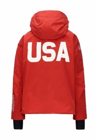 Giacca impermeabile rossa con cappuccio, caratterizzata da grandi lettere bianche "USA" sul retro e polsini neri sulle maniche. Logo Kappa sulla manica.