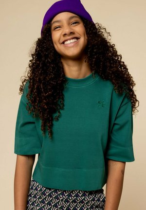 Groene katoenen cropped sweatshirt met korte mouwen en een ronde hals, voorzien van een kleine geborduurde bloemdetail aan de voorkant.