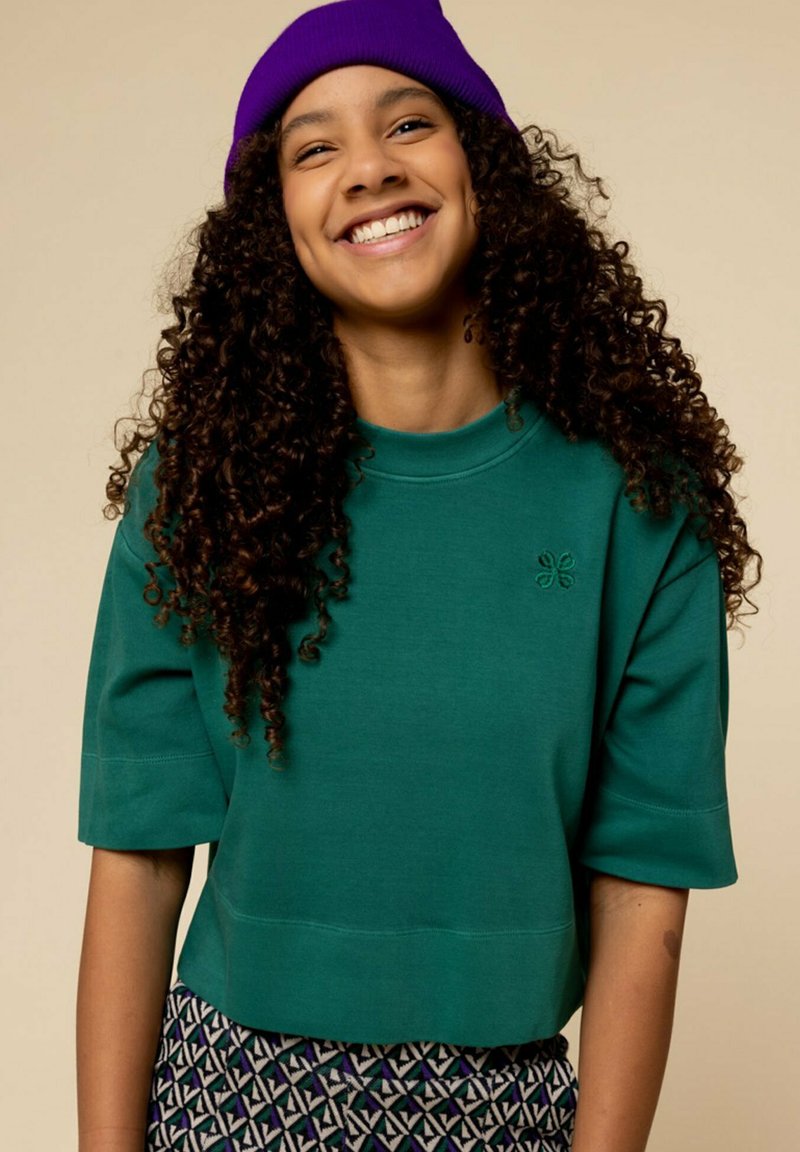 Groene katoenen cropped sweatshirt met korte mouwen en een ronde hals, voorzien van een kleine geborduurde bloemdetail aan de voorkant.