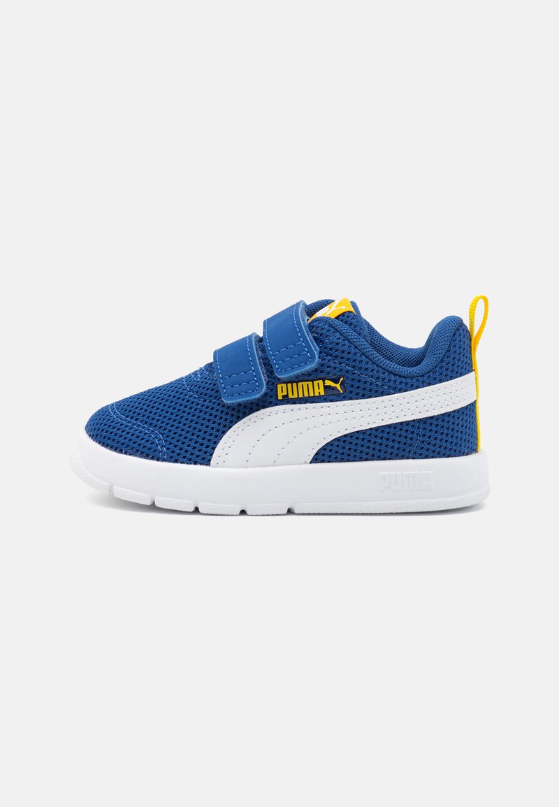 Zapatillas de malla azules con detalles blancos y amarillos. Presentan dos correas de Velcro y una suela texturizada para mayor agarre. Branding de Puma visible.