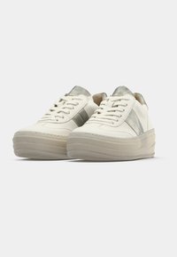 White canvas sneakers with a metallic silver accent, round toe, thick platform sole, and laced front. Soft texture and minimal design.