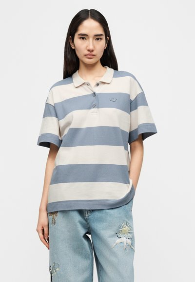 Polo rayé en gris clair et bleu, manches courtes, fermeture à boutons, en tissu texturé avec un petit logo sur la poitrine.