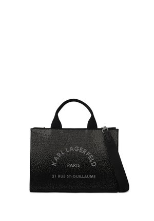 Sort rektangulær håndtaske med glitret tekstur, korte håndtag, en skulderrem og teksten "Karl Lagerfeld Paris 21 Rue St-Guillaume" foran.