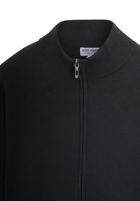 Suéter negro con cierre de cremallera, que presenta un cuello alto, una textura acanalada y una tela suave. La cremallera se extiende verticalmente por la parte delantera.