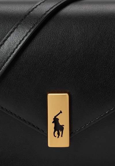 Bolso de mano de piel negra que presenta un hardware rectangular dorado con la silueta de un jugador de polo. Observar la textura suave y las líneas de diseño limpias.