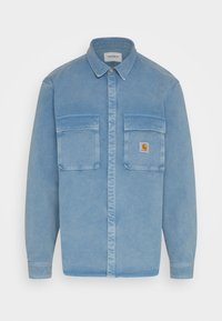 Camicia in denim blu chiaro con colletto, due tasche sul petto frontale e logo di marca applicato sulla tasca sinistra. Chiusura frontale con bottoni.