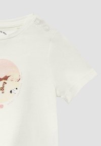 Kortek mouw witte shirt met een kleurrijke safari-thema graphic met een giraffe en koe ontwerp. Inclusief twee drukknoopjes op de schouder.