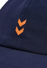 Marinkeps i slätt tyg med två framträdande orange chevronlogotyper, med strukturerad sömnad och en böjd skärm.