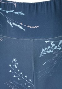 Leggings de color marino con un patrón floral en azul claro y rosa suave, con una textura suave y un diseño ajustado en la cintura y las costuras.