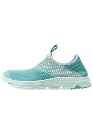Lyseblå slip-on sneakers med åndbar mesh-overdel, trækstrop på toppen og lys tekstureret sål designet til komfort og afslappet brug.