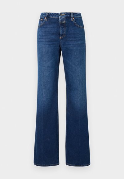 Jeans a zampa di elefante in denim blu scuro con chiusura a bottone e zip, cinque tasche e cuciture visibili lungo le cuciture.