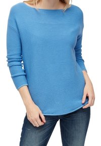 Pull à manches longues bleu clair avec une texture côtelée horizontale et un large décolleté, assorti à un jean bleu foncé.