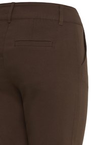 Pantalon marron sur mesure montrant une poche arrière à ouverture passepoilée et un détail de poche sur la couture latérale.