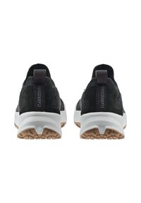 Un paio di scarpe atletiche nere e grigie con suole bianche e battistrada beige, viste da dietro, mostrando le linguette di brand con il testo "LOWA".