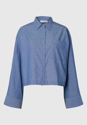 Modrá dlouhý rukáv krátká košile na knoflíky s hrotem límce a jedním náprsním kapsou na jednobarevném pozadí.