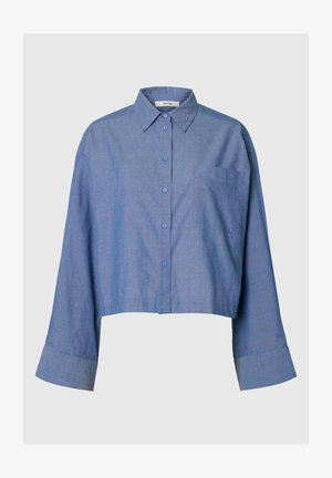 Modrá dlouhý rukáv krátká košile na knoflíky s hrotem límce a jedním náprsním kapsou na jednobarevném pozadí.