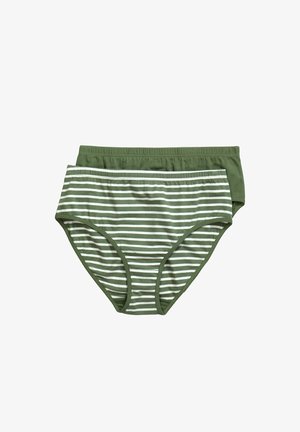 Frau mit langen, welligen Haaren, die grüne Brille, passenden olivgrünen Sport-BH und hoch taillierte Unterwäsche trägt, zieht leicht am Bund.