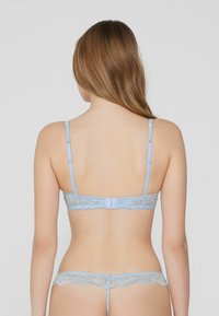 Light blue lace lingerie set featuring a minimalist back design, adjustable straps, and delicate lace trim on both the bra and briefs.