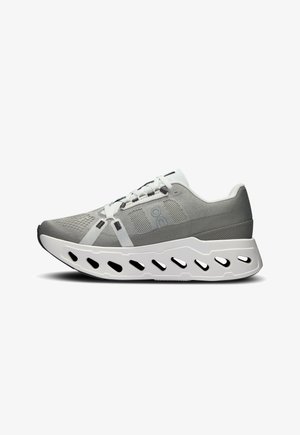 Chaussure de sport légère grise avec une tige texturée, des accents blancs, une semelle allongée et des découpes de ventilation pour la respirabilité.