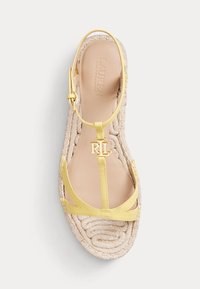 Žluté kožené ploché sandály s kotníkovým popruhem, pletenou juteovou podrážkou a zlatým logem RL na předním popruhu, navržené Laurena Ralph Lauren.