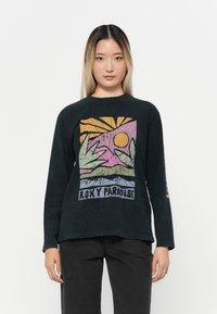 Svart langermet t-skjorte med en fargerik grafisk print av sol og blader, med teksten "ROXY PARADISE" nederst. Myk tekstur.