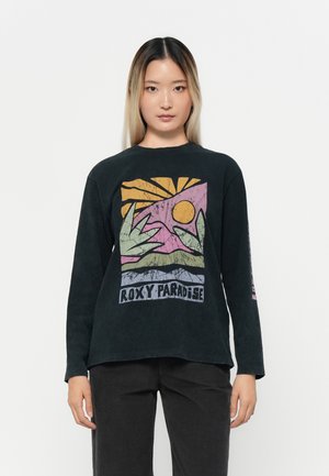 Black long-sleeve t-shirt featuring a colorful graphic print of sun and leaves with "ROXY PARADISE" text at the bottom. Soft texture.