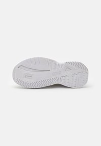Semelle blanche de sneaker avec motifs de grip texturés et marquage "Versace Jeans Couture" au centre, présentée sur un fond uni.