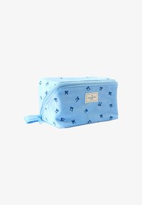 Bolso cosmético de tela azul con cierre de cremallera, con una textura suave y un patrón de pequeños lazos azul oscuro. Adornado con una etiqueta.