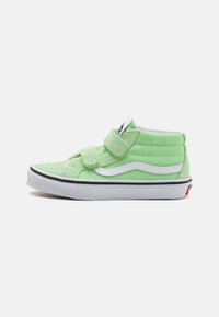 Zapatillas altas de color verde claro con acentos blancos, que presentan dos correas de velcro ajustables y una etiqueta de logo negra en la lengua.
