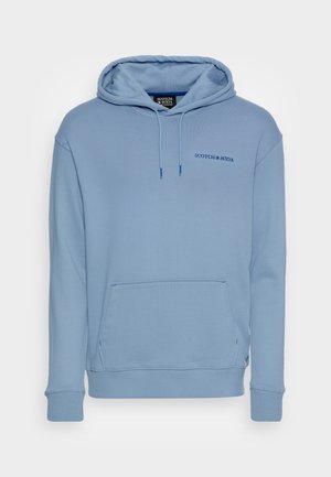 Jasnoniebieska bluza z kapturem, kieszenią z przodu, sznurkiem w kapturze, prążkowanymi mankietami i logo "Scotch & Soda" na piersi.