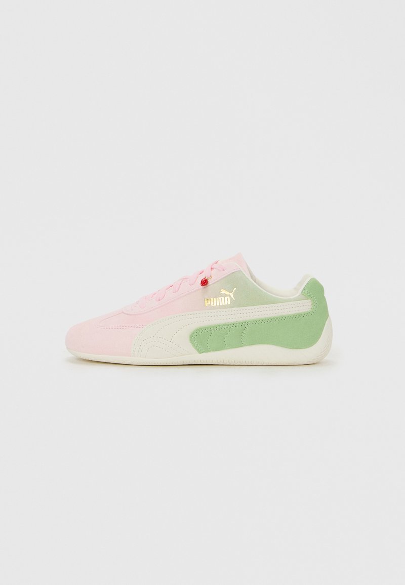 Lage Puma sneaker in pastelroze en groene suede met een witte zool en een gouden Puma-logo op een witte achtergrond.