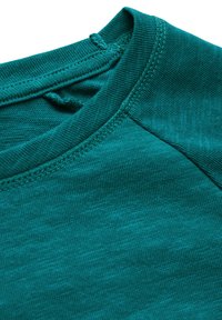 Teal puuvillane T-särk, millel on ümar kaelus, tekstuuriga kangas, tugevdatud õmblused ja silmusetikett seljal.