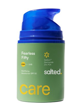 Groene moisturizerfles met blauwe pomp, gelabeld "Fearless Fifty" SPF 50, UVA+UVB, met SeaSync, niacinamide en zink PCA door Salted.