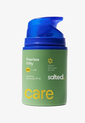 Groene moisturizerfles met blauwe pomp, gelabeld "Fearless Fifty" SPF 50, UVA+UVB, met SeaSync, niacinamide en zink PCA door Salted.