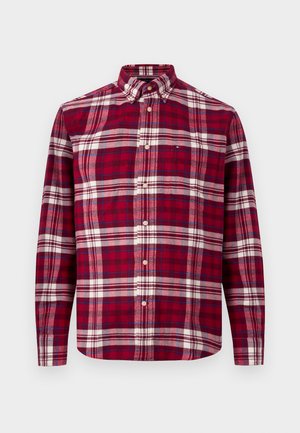 Camisa de manga larga a cuadros rojos y blancos con cuello abotonado y botones en la parte frontal. Hecha de una tela suave, cuenta con un bolsillo en el pecho y un dobladillo curvado.