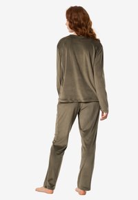 Komplet odzieży domowej w oliwkowo-zielonym kolorze, składający się z długiego rękawa i spodni, wykonany z miękkiej, pluszowej tkaniny o luźnym kroju i prostym designie.