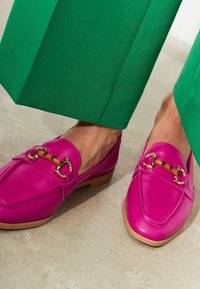 Fuchsia leren loafers met gouden hardware accenten. Heeft een uitgesproken teen vorm en een lichtbruine rubberen zool.