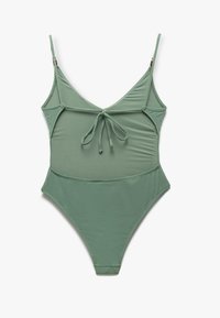 Maillot de bain une pièce vert avec des bretelles spaghetti réglables, un nœud à l'avant et une coupe haute sur les jambes. Fabriqué en matériau lisse et extensible.