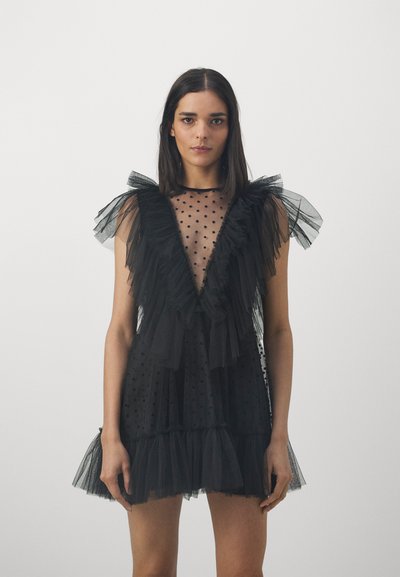 Black tulle dress with ruffled accents, polka dot texture, deep V-neck, and layered skirt. Sheer fabric and delicate shoulder details.