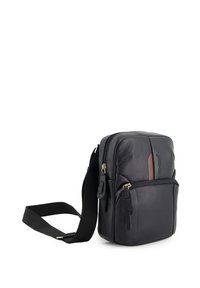 Schwarze Leder-Crossbody-Tasche mit glatter Textur, Reißverschlussfächern, verstellbarem Trageriemen und braunem Akzentpanel auf der Vorderseite.