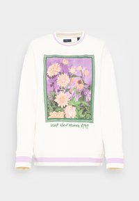 Sudadera de algodón en blanco roto con un diseño gráfico floral que presenta tonos de rosa y púrpura. Puños acanalados con acentos en lila.