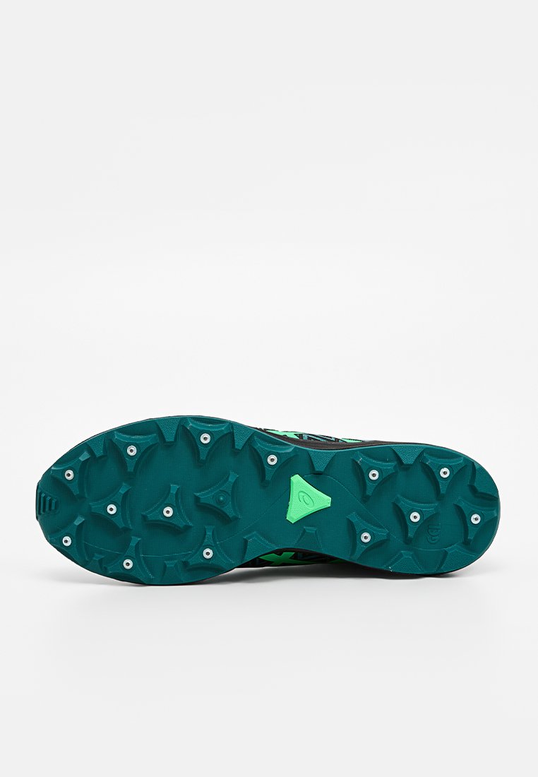 La suela de la zapatilla deportiva negra y verde agua presenta tacos multidireccionales para mayor tracción y una superficie texturizada. Acentos verdes decoran el talón.
