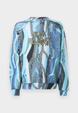 Strickpullover in Blau und Grün mit abstraktem Muster, Rundhalsausschnitt, gerippten Bündchen und Saum, mit dem Text "Crl0 C0l4cc1" in Gold.