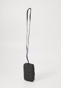 Sac à épaule rectangulaire noir avec une texture lisse, un profil mince, une fermeture zippée et une longue bandoulière réglable. Design minimaliste.
