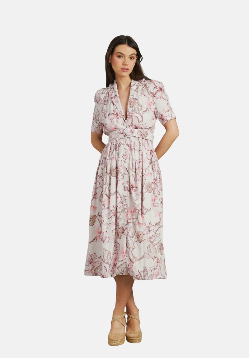 Abito midi floreale con scollatura a V, maniche corte a sbuffo e vita con lacci. Presenta motivi floreali rosa e beige su uno sfondo chiaro.